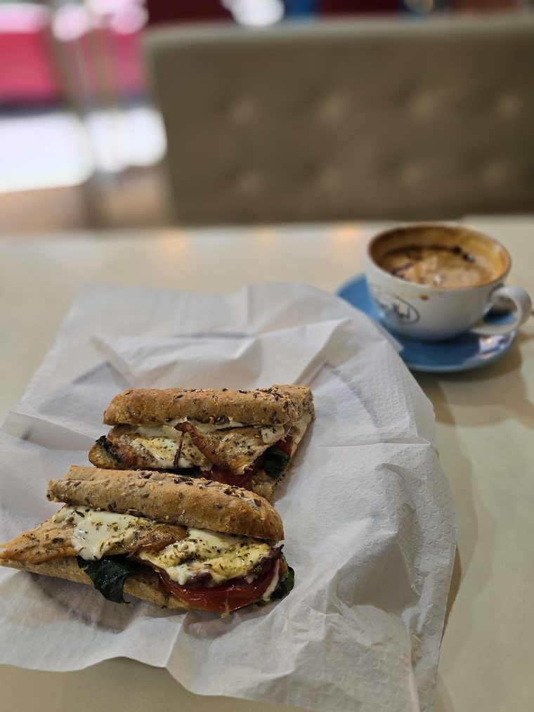 A toasted sandwich served with a cappuccino